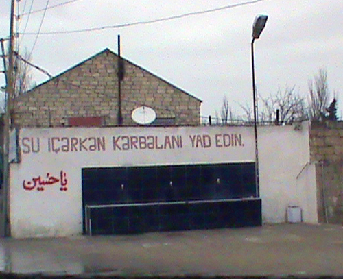 Улицы поселка Нардаран в Азербайджане, религиозный лозунг на стене: "Выпив воду, вспомни павших за веру в пустыне Кербелы". 2 января 2011 г. Фото "Кавказского узла"