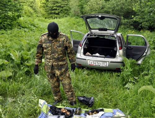 Сотрудник спецслужб у автомобиля, принадлежавшего одному из погибших в ходе перестрелки в Черекском районе КБР 1 июня 2013 г. Фото пресс-службы МВД КБР, http://07.mvd.ru