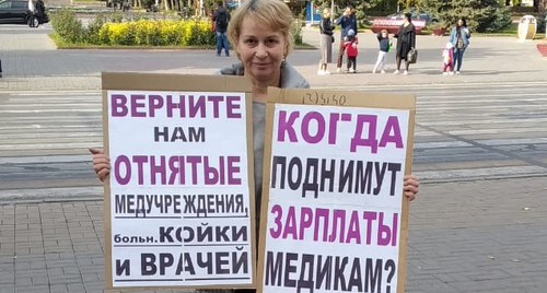 Активистка Тамара Гродникова держит плакаты с критикой реформы здравоохранения и с требованием повысить зарплаты врачам. Волгоград, 18 октября 2020 года. Фото Татьяны Филимоновой для "Кавказского узла".