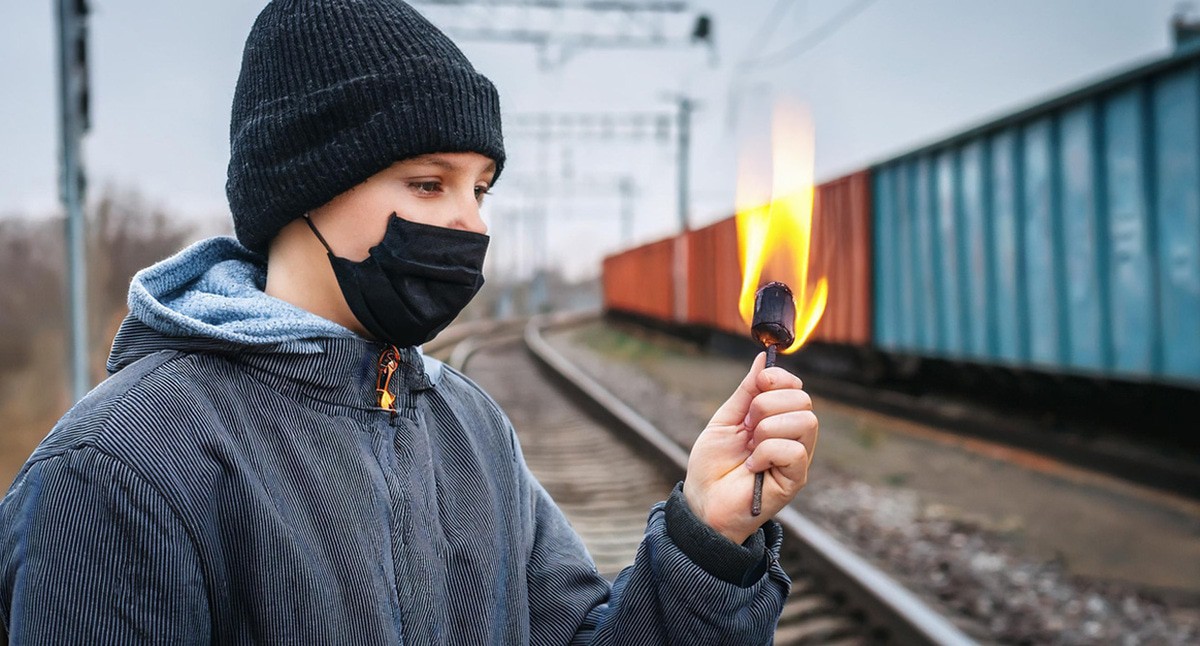 Подросток около железднодорожных путей. Иллюстрация создана "Кавказским узлом" с помощью ИИ в программе Photoshop